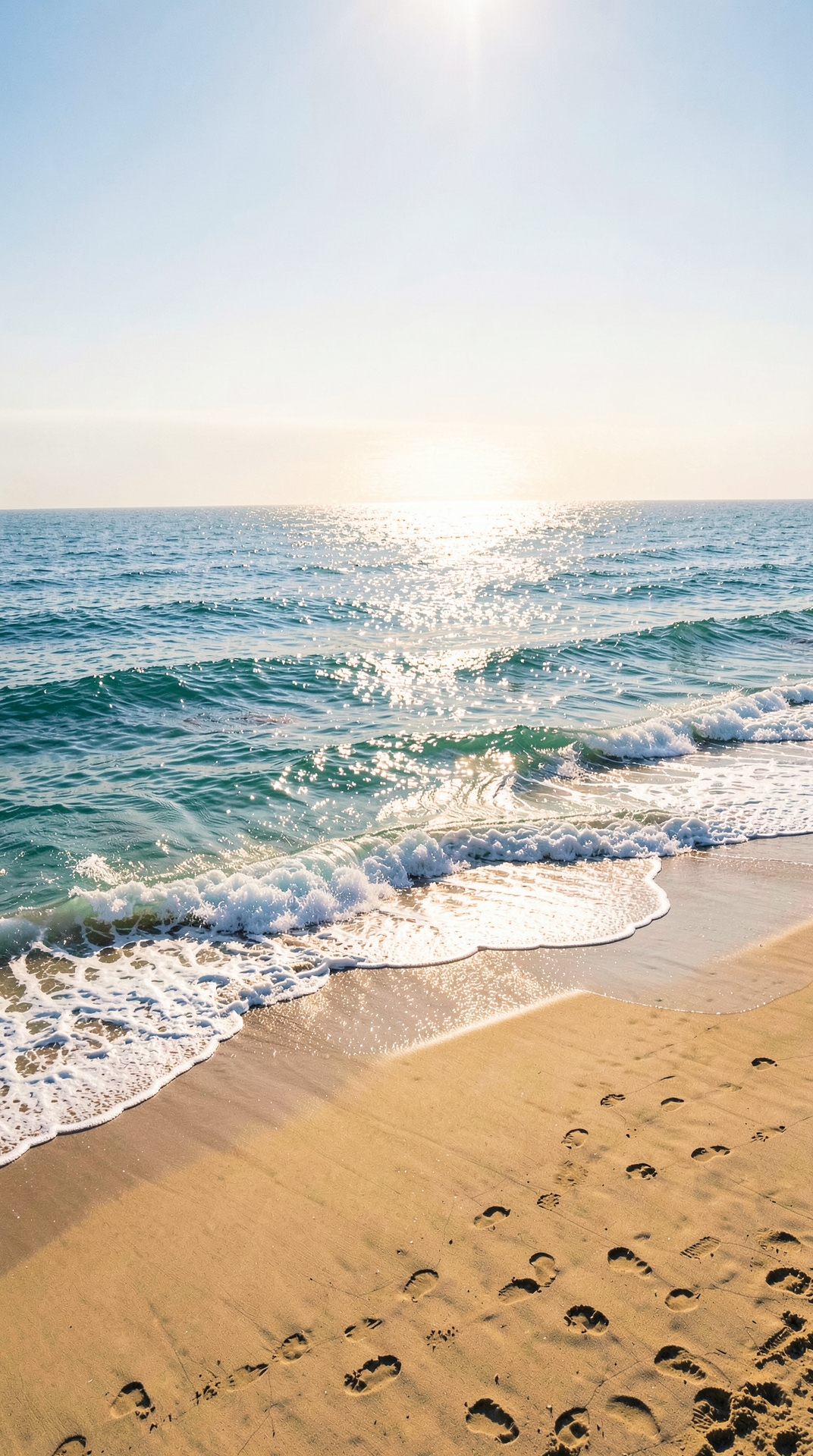 Aerial view of ocean waves crashing on sandy beach